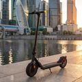 Sencor Scooter S25 zaparkovaná na nábreží moderného mesta pri západe slnka